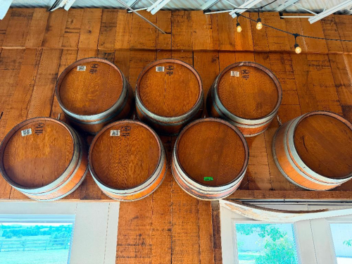 (7) WOOD WINE BARRELS MOUNTED HORIZONTALLY TO WALL, WITH WOOD STAVE CONSTRUCTION AND METAL HOOPS.