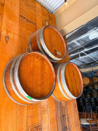 (3) WOOD WINE BARRELS MOUNTED HORIZONTALLY TO WALL, WITH WOOD STAVE CONSTRUCTION AND METAL HOOPS.