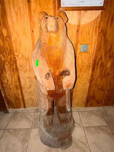 HAND-CARVED WOOD BEAR SCULPTURE CARVED FROM A SOLID LOG, FEATURING STANDING BEAR FORM WITH CARVED FACIAL FEATURES, PAWS, AND INTEGRAL LOG BASE.