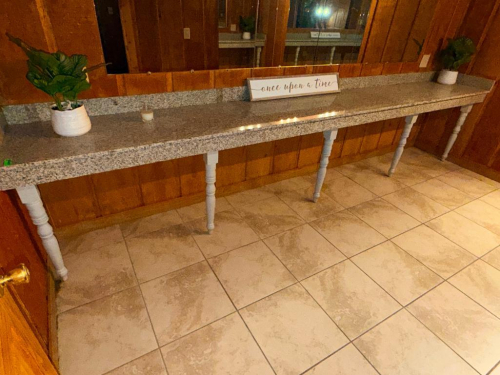 14' LONG GRANITE COUNTERTOP WITH GRANITE BACKSPLASH AND DECORATIVE TURNED SUPPORT LEGS.