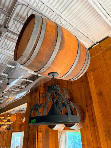 DECORATIVE HANGING WOODEN BARREL LIGHT FIXTURE WITH METAL HOOPS, CIRCULAR METAL LIGHT FRAME, AND DECORATIVE GRAPE VINE, LEAF, AND GRAPE CLUSTER ACCENTS. 20" SHADE.