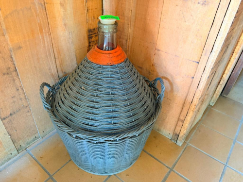 VINTAGE LARGE GLASS WINE DEMIJOHN / CARBOY WITH WOVEN WICKER PROTECTIVE BASKET, DUAL CARRY HANDLES, NARROW GLASS NECK AND STOPPER.