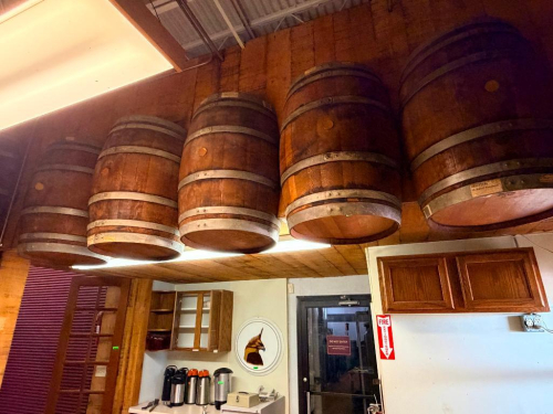 (7) WOOD WINE BARRELS MOUNTED HORIZONTALLY TO WALL, WITH WOOD STAVE CONSTRUCTION AND METAL HOOPS.