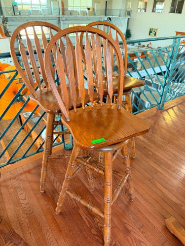 (3) 30" WOOD WINDSOR-STYLE BAR HEIGHT CHAIRS WITH HIGH SPINDLE BACKS, CONTOURED WOOD SEATS, TURNED LEGS AND FOOTREST STRETCHERS. MIXED OAK-TONE WOOD FINISHES.