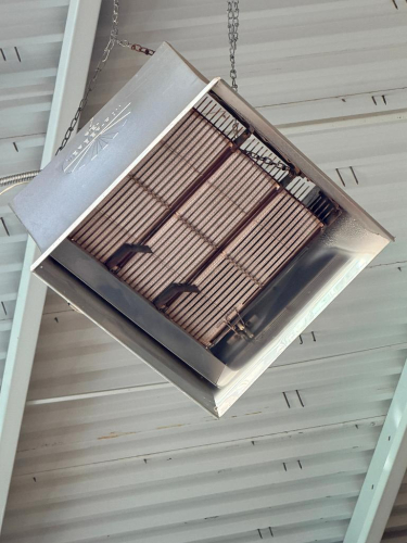 CEILING-MOUNTED GAS-FIRED INFRARED RADIANT HEATER WITH OPEN-FACE BURNER ASSEMBLY, METAL REFLECTOR HOUSING AND SUSPENSION CHAINS.