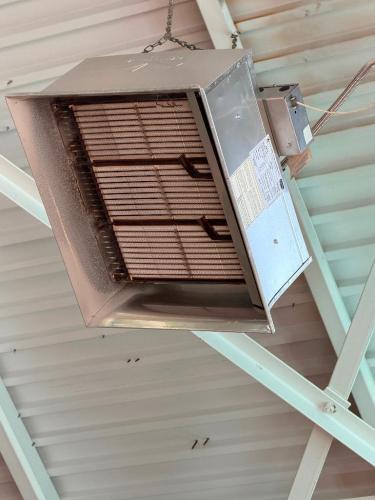 CEILING-MOUNTED GAS-FIRED INFRARED RADIANT HEATER WITH OPEN-FACE BURNER ASSEMBLY, METAL REFLECTOR HOUSING AND SUSPENSION CHAINS.
