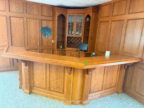 CUSTOM 10' X 10' L-SHAPED CORNER BAR WITH SOLID OAK CONSTRUCTION, RAISED WOOD BAR TOP, DECORATIVE RAISED-PANEL FRONT, FLUTED COLUMNS AND CARVED CORBELS. INCLUDES MATCHING CORNER BACK BAR CABINETRY WITH GLASS DISPLAY SHELVING, GLASS-FRONT CABINET, WINE BOT