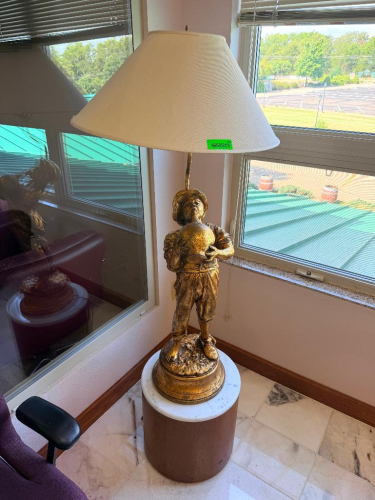 DECORATIVE FIGURAL TABLE LAMP FEATURING A GOLD-TONE FIGURE HOLDING A LARGE SPHERE, MOUNTED ON A ROUND PEDESTAL BASE WITH WHITE FABRIC LAMP SHADE.
