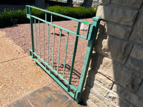 CUSTOM POWDER-COATED METAL SWING GATE WITH VERTICAL BAR DESIGN, SQUARE TUBE FRAME, HINGES AND SUPPORT POST.