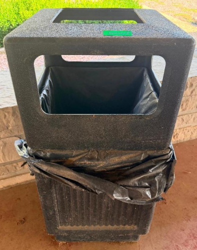 (2) OUT BLACK PLASTIC TRASH CANS.