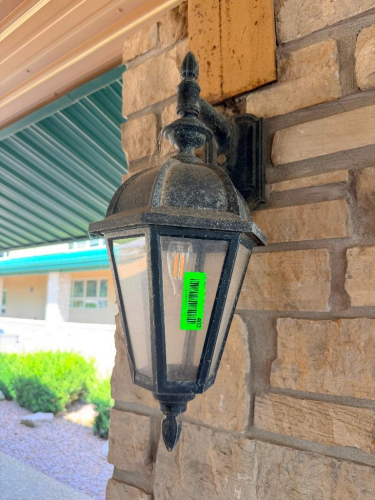 (9) DECORATIVE WALL-MOUNT LANTERN LIGHT FIXTURE WITH BLACK FINISH, ORNATE BACKPLATE AND SUPPORT BRACKET, CLEAR CURVED GLASS PANELS, AND MULTI-LIGHT CANDELABRA-STYLE INTERIOR.