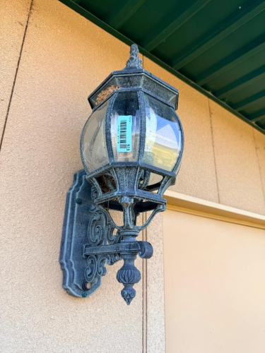 (3)DECORATIVE WALL-MOUNT LANTERN LIGHT FIXTURE WITH BLACK FINISH, ORNATE BACKPLATE AND SUPPORT BRACKET, CLEAR CURVED GLASS PANELS, AND MULTI-LIGHT CANDELABRA-STYLE INTERIOR.