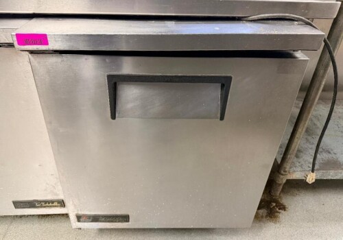 TRUE UNDERCOUNTER FREEZER WITH STAINLESS STEEL EXTERIOR, SINGLE SOLID HINGED DOOR, RECESSED HANDLE, AND REAR INTERIOR EVAPORATOR ASSEMBLY.