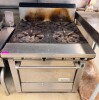GARLAND COMMERCIAL GAS RANGE WITH FOUR OPEN TOP BURNERS AND STANDARD OVEN BASE. FEATURES HEAVY CAST-IRON BURNER GRATES, STAINLESS STEEL FRONT AND SIDES, REAR FLUE RISER, OVEN DOOR WITH FULL-WIDTH HANDLE, AND MULTIPLE OVEN RACKS.