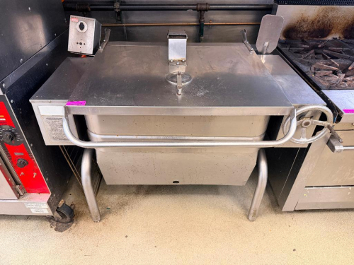 TILTING BRAISING PAN / TILT SKILLET WITH STAINLESS STEEL CONSTRUCTION, DEEP RECTANGULAR COOKING PAN, HINGED LID WITH FULL-WIDTH HANDLE, MANUAL HANDWHEEL TILT MECHANISM, THERMOSTATIC TEMPERATURE CONTROL, AND GAS-FIRED HEATING SYSTEM.