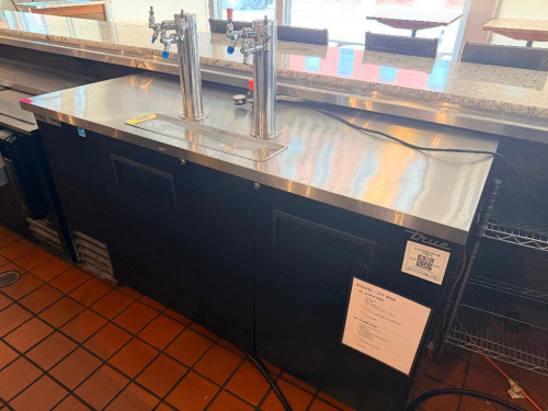 TRUE THREE-DOOR COMMERCIAL DIRECT-DRAW KEG REFRIGERATOR WITH BLACK EXTERIOR, STAINLESS STEEL TOP, THREE SOLID SWING DOORS, TWO STAINLESS STEEL DRAFT TOWERS WITH MULTIPLE BEER FAUCETS, AND RECESSED STAINLESS STEEL DRIP TRAY. INCLUDES BEER LINES AND ASSOCIA