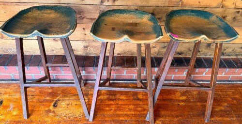 (3) 30" PINE WOOD BAR STOOLS WITH NATURAL LIVE-EDGE STYLE SADDLE SEATS AND FOUR-LEG WOOD BASES WITH FOOTREST SUPPORTS. SEATS SHOW A DARK STAINED FINISH WITH EXPOSED NATURAL WOOD ALONG THE EDGES.