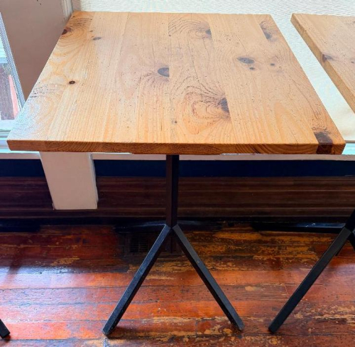 32" WIDE X 24" PINE PUB TABLE WITH THICK SOLID WOOD TOP AND BLACK METAL PEDESTAL BASE. RECTANGULAR TOP FEATURES VISIBLE NATURAL KNOTS AND WOOD GRAIN WITH A CLEAR/NATURAL FINISH.