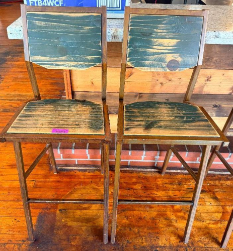 (2) WOOD AND METAL BAR HEIGHT CHAIRS WITH SOLID WOOD SEATS AND BACKREST PANELS, SQUARE TUBULAR STEEL FRAMES, AND INTEGRATED FOOTRESTS. DISTRESSED DARK FINISH