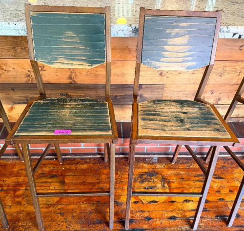 (2) WOOD AND METAL BAR HEIGHT CHAIRS WITH SOLID WOOD SEATS AND BACKREST PANELS, SQUARE TUBULAR STEEL FRAMES, AND INTEGRATED FOOTRESTS. DISTRESSED DARK FINISH
