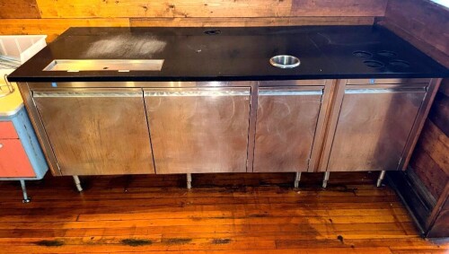 92" LONG X 36" CRAFT MFG COMMERCIAL STAINLESS STEEL BACK BAR / SERVICE COUNTER WITH BLACK SOLID-SURFACE TOP, MULTIPLE STAINLESS STEEL CABINET DOORS, ADJUSTABLE LEGS, BUILT-IN RECESSED PAN AREA, ROUND DROP-IN CUP/CONTAINER WELL, AND MULTIPLE ROUND CUTOUTS.