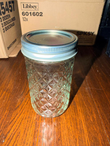 (1) MILK CRATE FULL OF SMALL MASON JARS W/ LIDS.