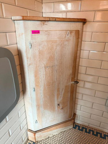 30" WIDE X 18" CUSTOM-BUILT RUSTIC WOOD CORNER STORAGE CABINET WITH SINGLE FULL-LENGTH HINGED DOOR, INTERIOR SHELVING, METAL LATCH HARDWARE, AND TWO-TONE DISTRESSED WOOD FINISH.