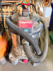 SHOP-VAC HEAVY-DUTY WET/DRY SHOP VACUUM WITH STAINLESS STEEL COLLECTION TANK, LARGE REAR WHEELS, FRONT CASTERS, PUSH HANDLE, DRAIN PORT, AND FLEXIBLE VACUUM HOSE.