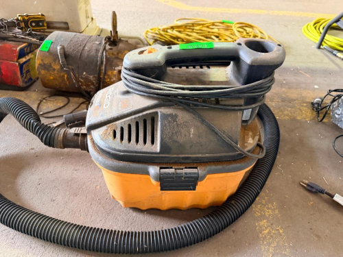 RIDGID PORTABLE WET/DRY VACUUM WITH 4-GALLON COLLECTION TANK, INTEGRATED CARRY HANDLE, FLEXIBLE VACUUM HOSE, POWER CORD, AND LATCHED MOTOR HEAD ASSEMBLY.