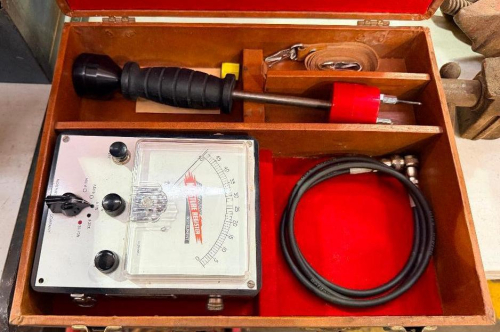 ELECTRIC MOISTURE TESTER IN FITTED WOODEN CARRYING CASE WITH ANALOG METER, HANDHELD PROBE, CONNECTING CABLE, ACCESSORIES AND OPERATING CONTROLS.
