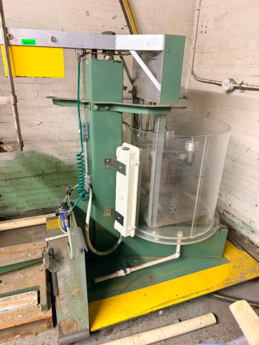 MAGNA VISION 25-90 INDUSTRIAL PARTS WASHING / CLEANING MACHINE WITH ROTATING WORK AREA, CLEAR CYLINDRICAL SAFETY ENCLOSURE, PERFORATED WORK PLATFORM, OVERHEAD DRIVE ASSEMBLY, PNEUMATIC COMPONENTS AND INTEGRATED FLUID PLUMBING.