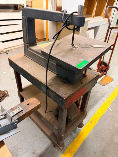 HEAVY-DUTY INDUSTRIAL SCROLL SAW WITH CAST METAL FRAME, LARGE RECTANGULAR WORK TABLE, VERTICAL RECIPROCATING BLADE AND FLOOR-STAND BASE.