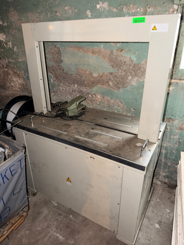 SEMI-AUTOMATIC ARCH STRAPPING MACHINE WITH STAINLESS STEEL WORK SURFACE, INTEGRATED STRAP DISPENSER, FOOT PEDAL CONTROL, TENSION ADJUSTMENT, RESET CONTROL, AND AUTOMATIC STRAP FEEDING/SEALING SYSTEM.