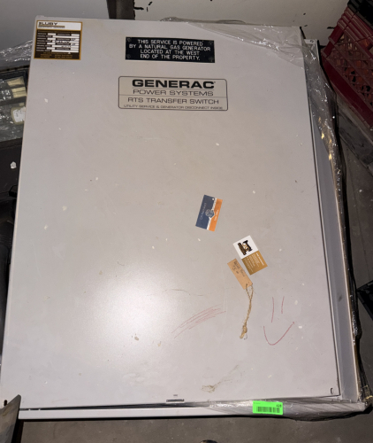 GENERAC RTS AUTOMATIC TRANSFER SWITCH IN METAL ENCLOSURE WITH UTILITY SERVICE AND GENERATOR DISCONNECTS.