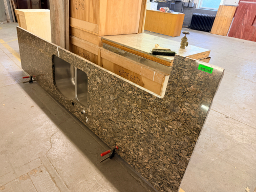 12' GRANITE COUNTERTOP WITH UNDERMOUNT DOUBLE-BOWL STAINLESS STEEL SINK, POLISHED FRONT EDGE, FAUCET/ACCESSORY CUTOUTS, AND MATCHING GRANITE END SECTION.