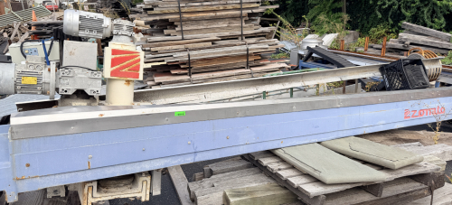 ZONATO INDUSTRIAL STONE FABRICATION BRIDGE SAW / CUTTING SYSTEM WITH LONG TRAVEL RAIL ASSEMBLY, MOTORIZED DRIVE SYSTEM, REMOTE OPERATOR CONTROL PANEL, PNEUMATIC COMPONENTS, CABLE CARRIERS, AND ASSOCIATED CONTROL EQUIPMENT.