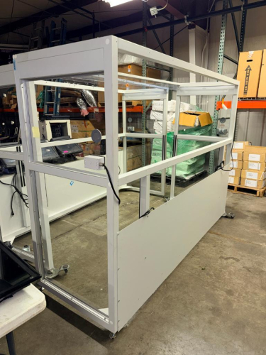 CAMFIL MOBILE CLEAN AIR ENCLOSURE SYSTEM CONSISTING OF A LARGE ALUMINUM-FRAMED ENCLOSURE WITH CLEAR PANEL WALLS, ROLLING CASTERS, INTEGRATED ELECTRICAL OUTLETS, OVERHEAD LIGHTING AND CAMFIL HEPA FILTRATION COMPONENTS. INCLUDES TWO LARGE FILTER / AIR HANDL