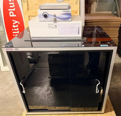 AIRFILTRONIX RF-1000 AIR FILTRATION / BLOWER SYSTEM MOUNTED ON AN ENCLOSED LABORATORY WORKSTATION WITH BLACK PANEL CONSTRUCTION AND FRONT ACCESS DOORS. UNIT INCLUDES VARIABLE AIRFLOW CONTROL, FILTER ASSEMBLY, AND INTERNAL AUTOMATED ROBOTIC SAMPLE-HANDLING