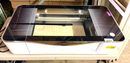 GLOWFORGE PRO DESKTOP CO2 LASER CUTTER AND ENGRAVER WITH PASS-THROUGH SLOT, LIFTING GLASS LID, INTERNAL WORK BED AND INTEGRATED EXHAUST SYSTEM.