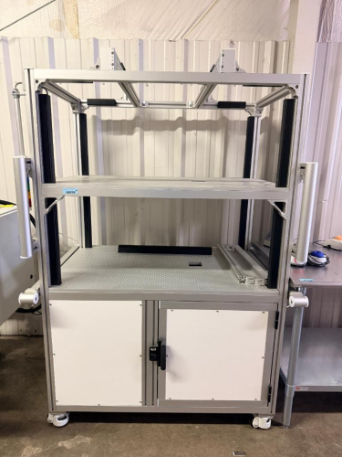 CUSTOM MOBILE ALUMINUM EXTRUSION WORKSTATION / AUTOMATION ENCLOSURE WITH DUAL PERFORATED WORK SURFACES, UPPER EQUIPMENT FRAME, LOWER ENCLOSED CABINET, ADJUSTABLE SIDE-MOUNTED SUPPORT ARMS, STACK SIGNAL LIGHT AND INTERNAL ELECTRICAL COMPONENTS.