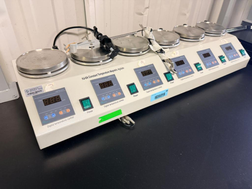 SIX-POSITION CONSTANT TEMPERATURE MAGNETIC AGITATOR WITH INDIVIDUAL STAINLESS STEEL HEATING/STIRRING PLATFORMS, DIGITAL TEMPERATURE CONTROLLERS AND INDEPENDENT POWER SWITCHES. INCLUDES CLAMP AND SUPPORT HARDWARE AS SHOWN.