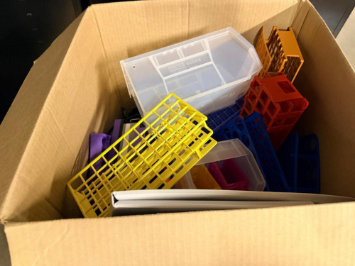 (1) BOX OF ASSORTED PLASTIC LABORATORY TEST TUBE RACKS AND SAMPLE TUBE HOLDERS IN VARIOUS SIZES, CONFIGURATIONS, AND COLORS. INCLUDES RED, BLUE, WHITE, PURPLE, ORANGE, YELLOW, AND OTHER ASSORTED RACKS. SOLD AS ONE BULK LOT WITH CONTENTS OF CARTON.