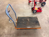 1,100 LB. CAPACITY MANUAL HYDRAULIC LIFT TABLE CART WITH STEEL PLATFORM, NON-SLIP RUBBER DECK SURFACE, FOOT-OPERATED HYDRAULIC PUMP, MANUAL LOWERING CONTROL, PUSH HANDLE, AND FOUR SWIVEL CASTERS. - 2