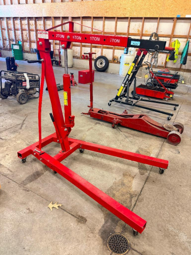 2 TON FOLDING HYDRAULIC ENGINE HOIST WITH TELESCOPING BOOM, 8 TON HYDRAULIC LONG RAM JACK, MANUAL PUMP HANDLE, STEEL LIFTING HOOK, AND FOLDING STEEL BASE WITH SWIVEL CASTERS.