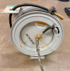 KUTCH HEAVY-DUTY RETRACTABLE AIR HOSE REEL WITH ENCLOSED STEEL DRUM, SPRING-LOADED RETRACTION MECHANISM, RUBBER AIR HOSE, BRASS AIR FITTINGS AND STEEL MOUNTING BRACKET.