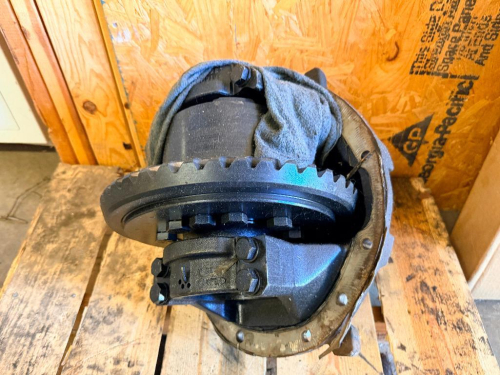 USED HEAVY-DUTY COMMERCIAL TRUCK REAR AXLE DIFFERENTIAL THIRD MEMBER ASSEMBLY WITH RING GEAR, DIFFERENTIAL CARRIER, BEARING CAPS, AND CAST METAL HOUSING.