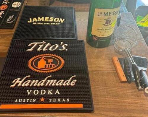 (3) ASSORTED BAR MATS AND (1) EMPTY JAMESON HANDLE.