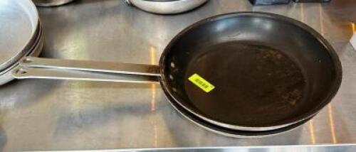 NAME: (2)- SKILLETS DESCRIPTION: (2)- SKILLETS SIZE: 14" LOCATION: FRONT ENTRANCE QTY: 2