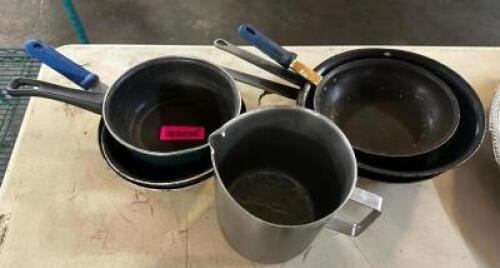 (4) ASSORTED SKILLETS AND (1) MEASURING CUP.