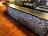 DESCRIPTION 200" X 26" BLACK COMPOSITE BAR TOP WITH WOODEN TRIM, CAST IRON FOOT RAIL, AND WOODEN ARCH BAR BACK. ADDITIONAL INFORMATION LOGO MIRROR IS - 6